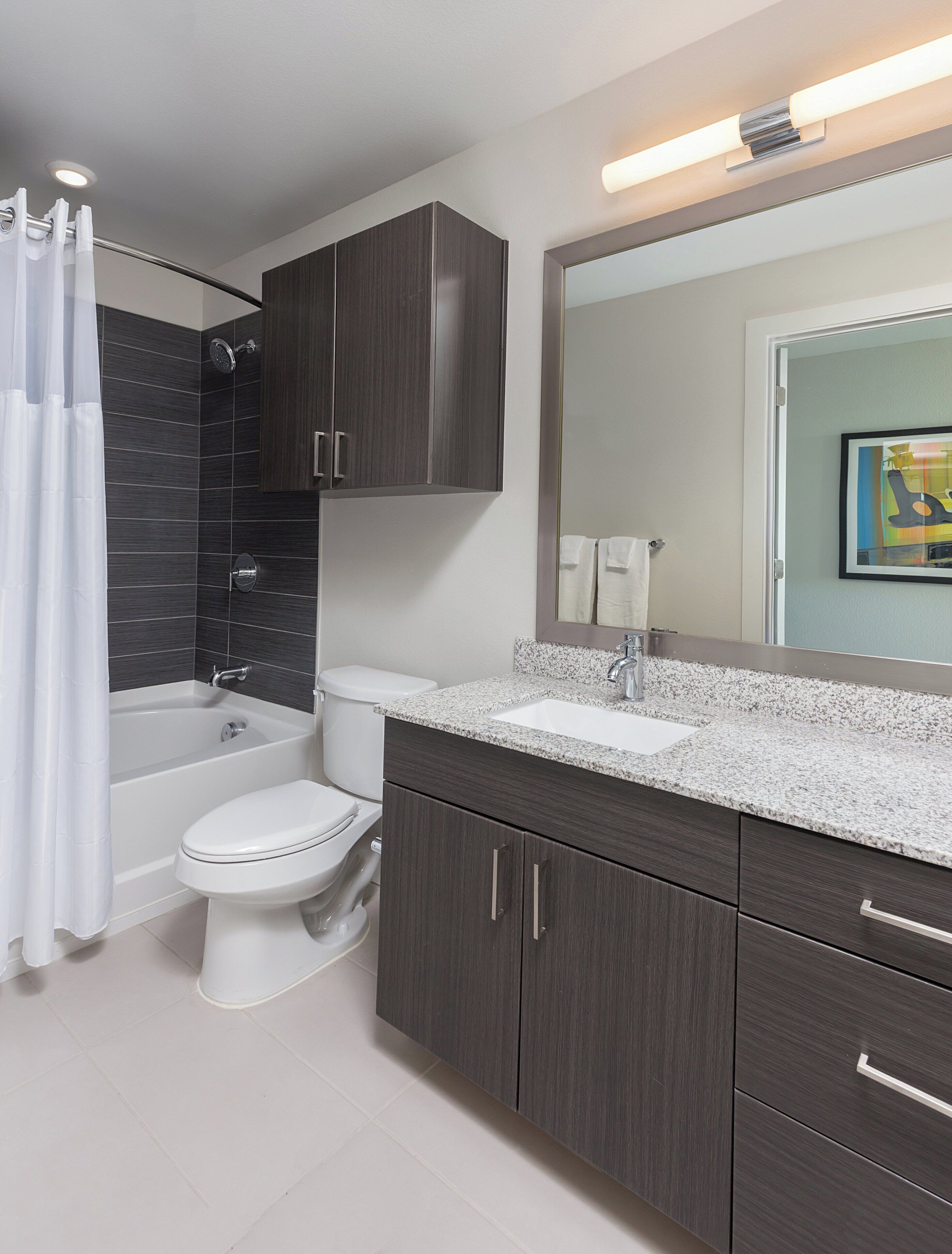 A modern bathroom with a bathtub, toilet, and sink.