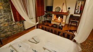 Ein Hotelzimmer mit Bett, Kamin, Fernseher und Spiegel.