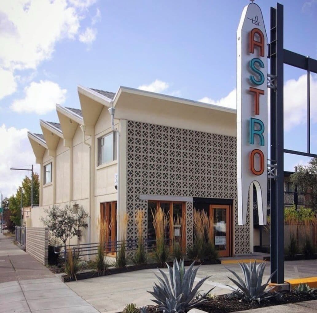 A building with a sign reading "ASTRO" and a modern architectural design with a patterned facade and a flat roof.
