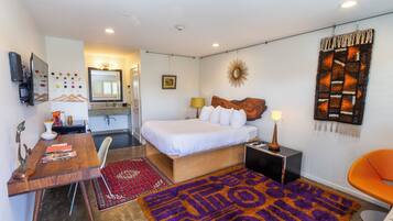 Un dormitorio moderno con cama, mesita de noche, lámpara y alfombra decorativa.