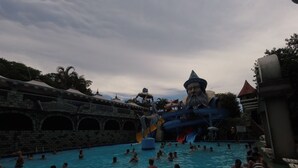 A swimming pool area with a water slide and a castle-like structure. - Regina Del Mare Residence (Florianópolis)