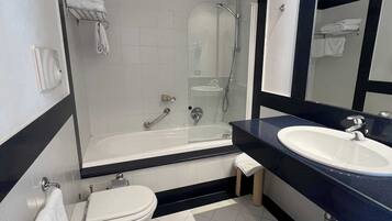 A modern bathroom with a bathtub, toilet, and sink.