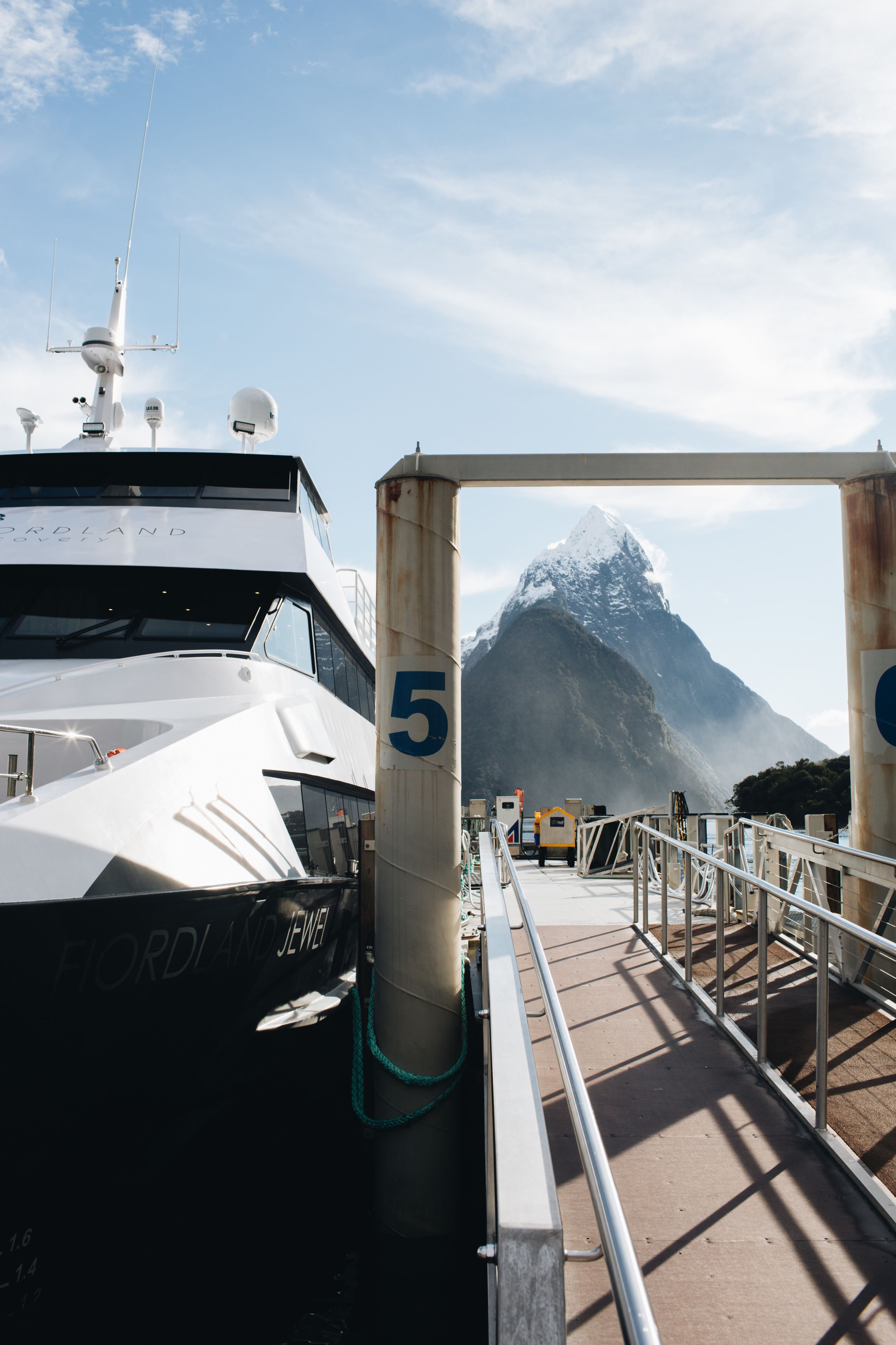 Un muelle de ferry con una gran montaña al fondo.