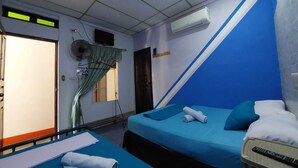 Habitación de hotel con dos camas, ventilador de techo, aire acondicionado y ventana con cortinas.