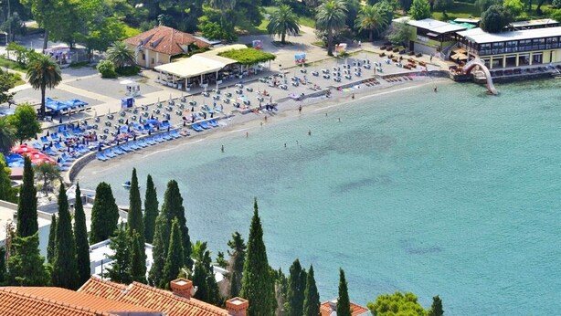 A coastal hotel with a beach area, including sun loungers and umbrellas, and a view of the sea. - Apartments Mira (Dubrovnik)