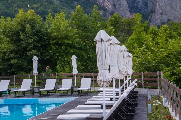 Una piscina techada, una piscina al aire libre, sombrillas