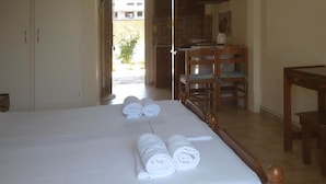 Una habitación de hotel con una cama, una mesa de madera, una silla y un escritorio.