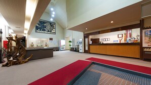 A spacious lobby with a reception desk, a large abstract sculpture, and a red carpet leading to the entrance. - Tajimakan (Takayama)