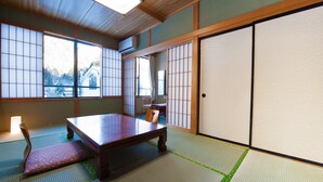 A traditional Japanese room with tatami flooring, a low wooden table, and sliding shoji doors. - Tajimakan (Takayama)