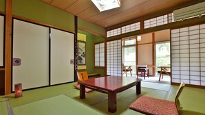A traditional Japanese room with tatami flooring, a low wooden table, sliding doors, and large windows. - Tajimakan (Takayama)