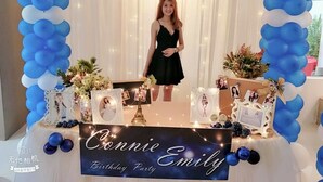 Syntymäpäiväjuhlien järjestelyt, joihin kuuluu kyltti, jossa lukee ”Connie Emilyn syntymäpäiväjuhlat”, sekä koristeellinen ilmapallokaari.