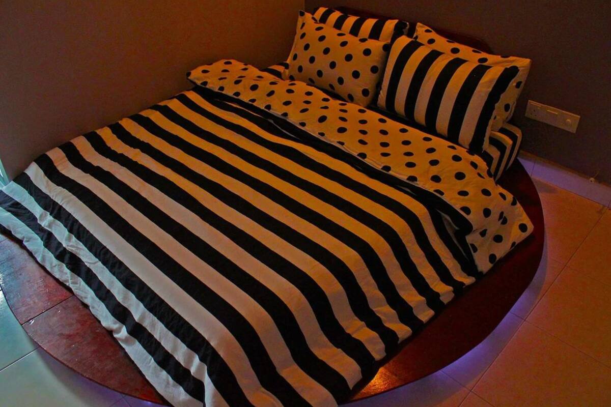 Een bed met zwart-wit gestreepte dekbedden en stippeldeken kussens.