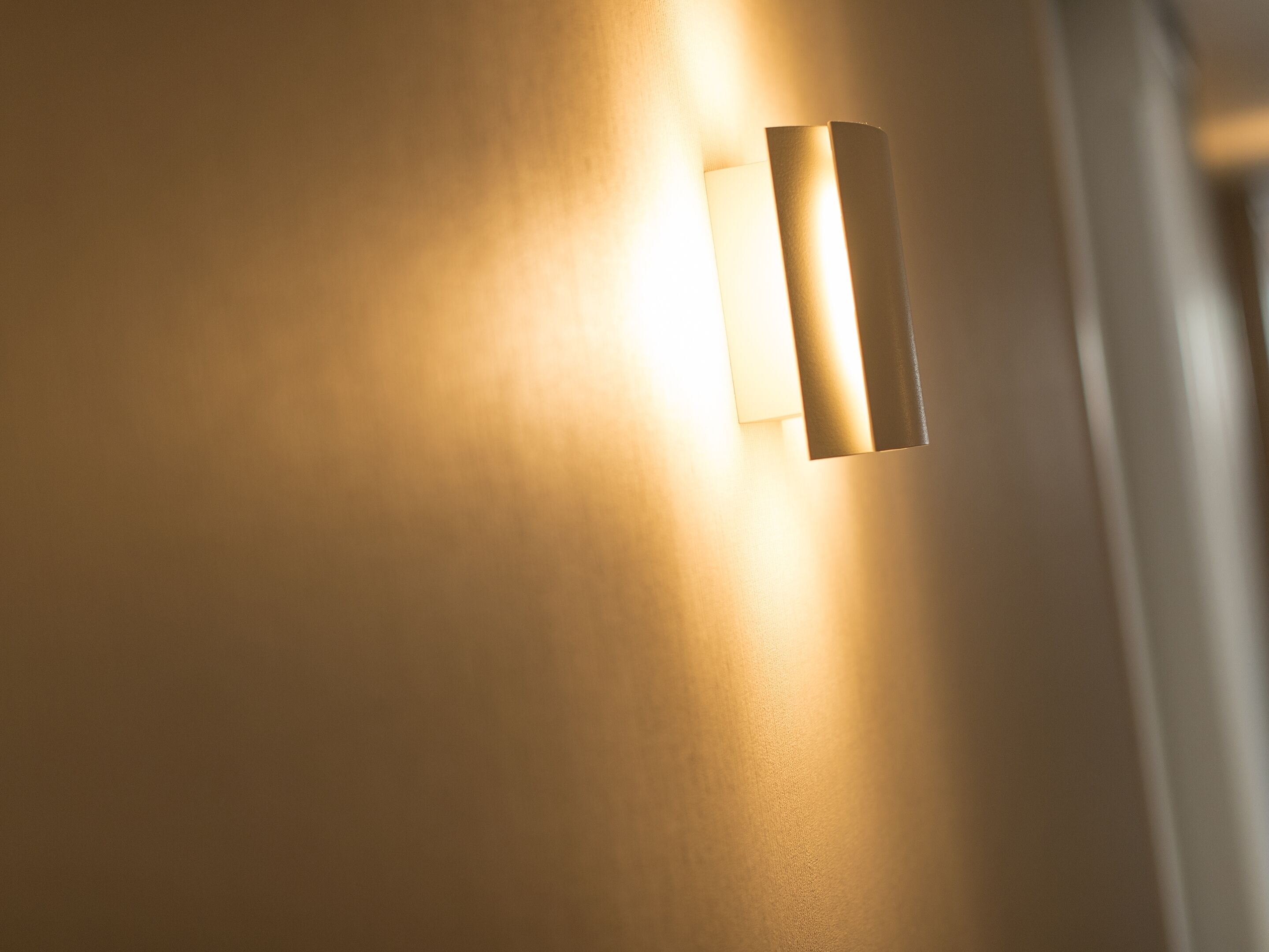 A wall-mounted light fixture with a rectangular shape and a narrow, elongated design.