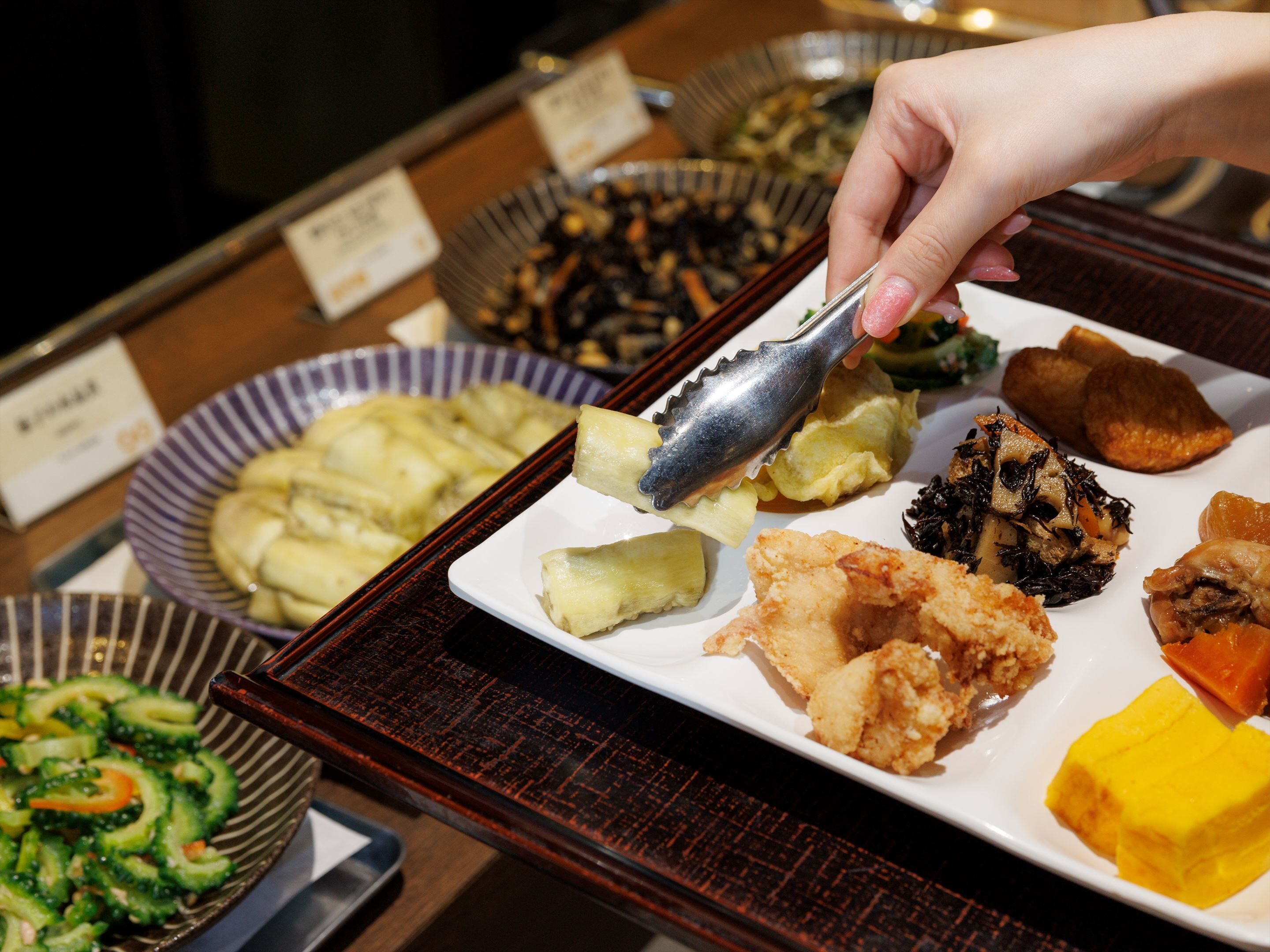 A buffet with various dishes including fried items, vegetables, and a variety of side dishes.