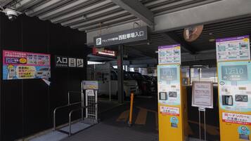 A parking garage entrance with a sign indicating the entrance and an elevator.
