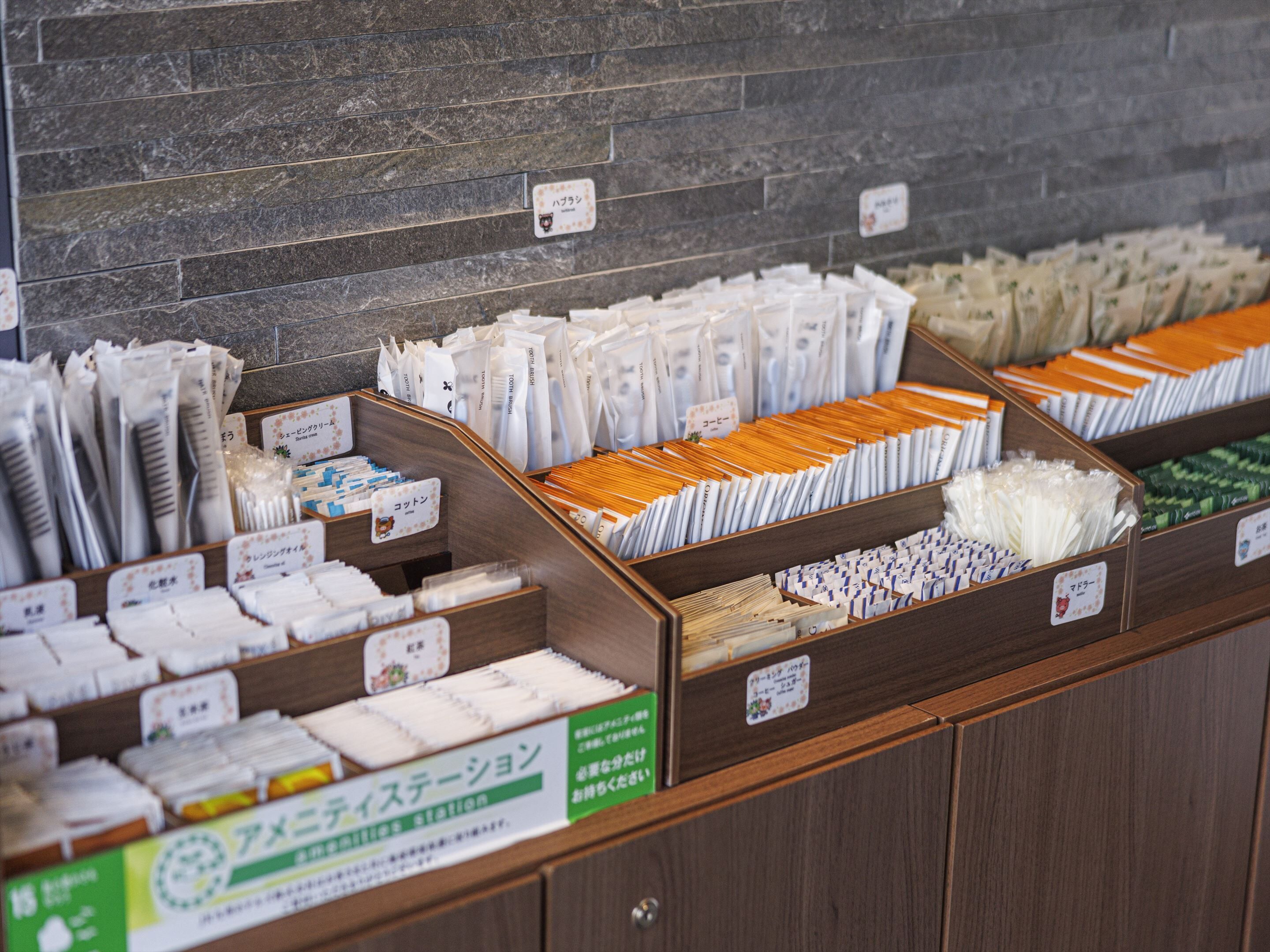 A display of various packaged goods, including toothbrushes and other toiletries, organized in wooden bins with labels.