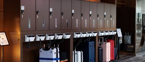 A row of luggage storage lockers with numbered compartments and a signboard.