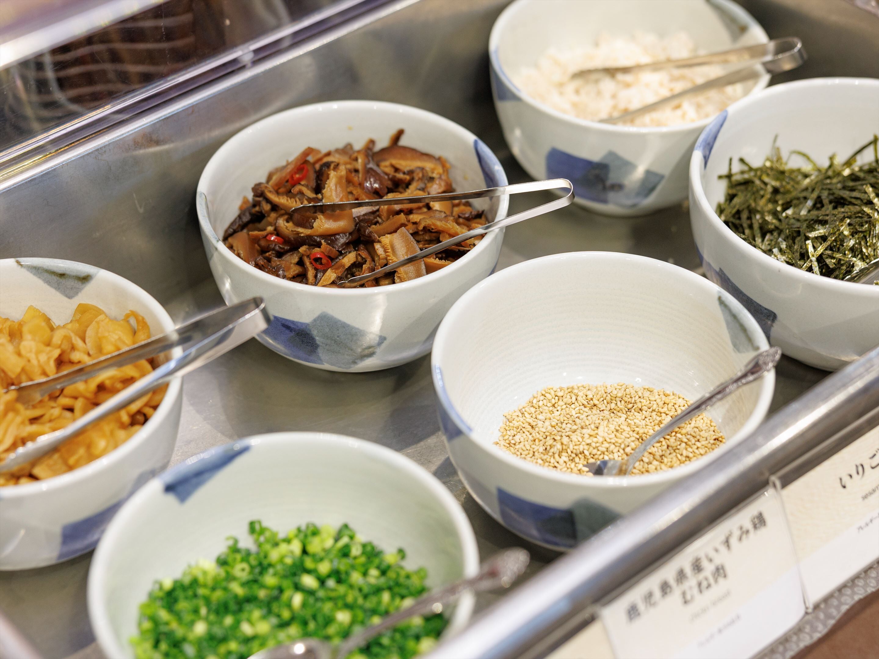 Ein reichhaltiges Buffet mit verschiedenen Speisen, darunter Nudeln, Gemüse und Getreide.
