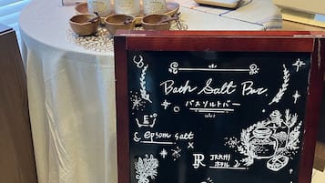 A table with salt jars and wooden bowls, a chalkboard menu with Japanese text, and a wooden counter.