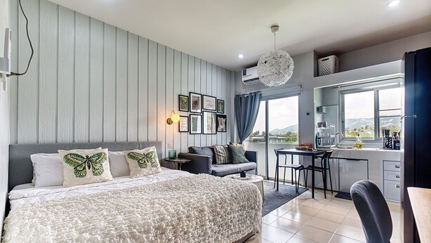 Un dormitorio con una cama grande, un escritorio y vistas al exterior.