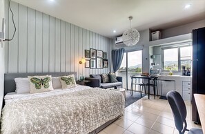 Une chambre avec un grand lit, un bureau et une vue sur l’extérieur.