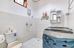 Une salle de bain équipée de toilettes, d’une douche, d’un lavabo et d’un miroir.