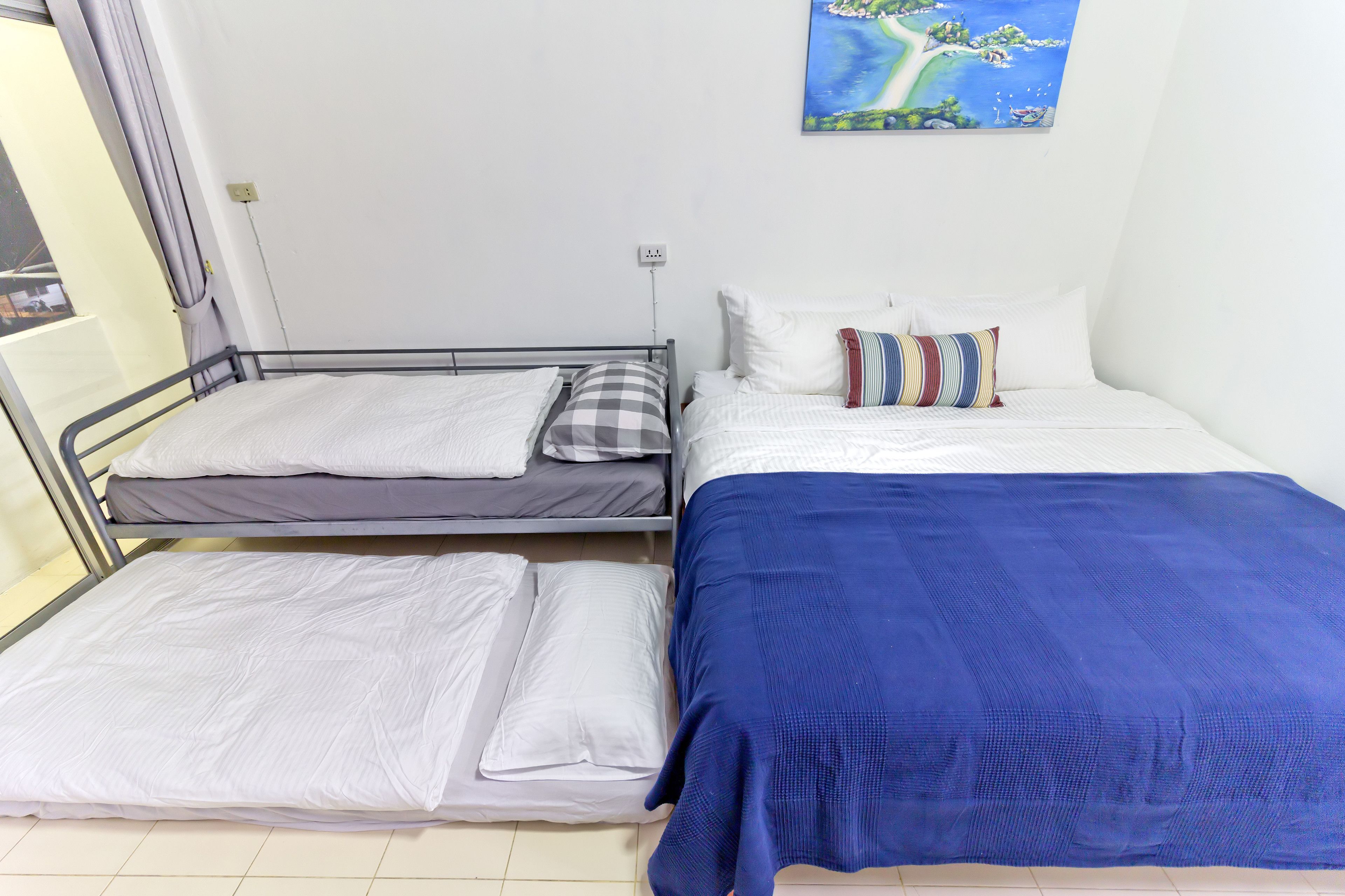 Una stanza con un letto, un letto aggiuntivo e una finestra.