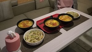 A dining table with four bowls of food, a tissue dispenser, and a painting on the wall. - Beijing Badaling Great Wall Caos Hostel (Yanqing)