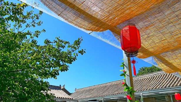 A traditional building with a tiled roof and a covered patio area. - Beijing Badaling Great Wall Caos Hostel (Yanqing)