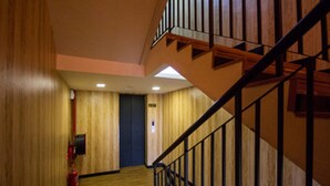 A wooden-floored hallway with a staircase and a fire extinguisher on the wall. - S Hotel (Seberang Jaya)
