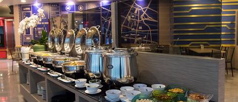 A buffet setup with multiple food service stations, including large pots and bowls of food, arranged on a counter.