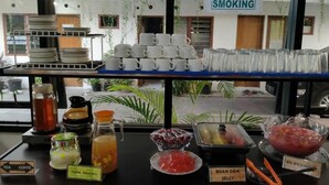 Un bufé con té, café, infusiones, mermelada y diversas frutas y aperitivos.