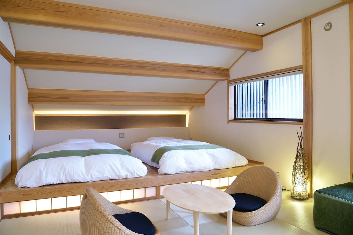 A room with two beds, a small table, and two chairs.