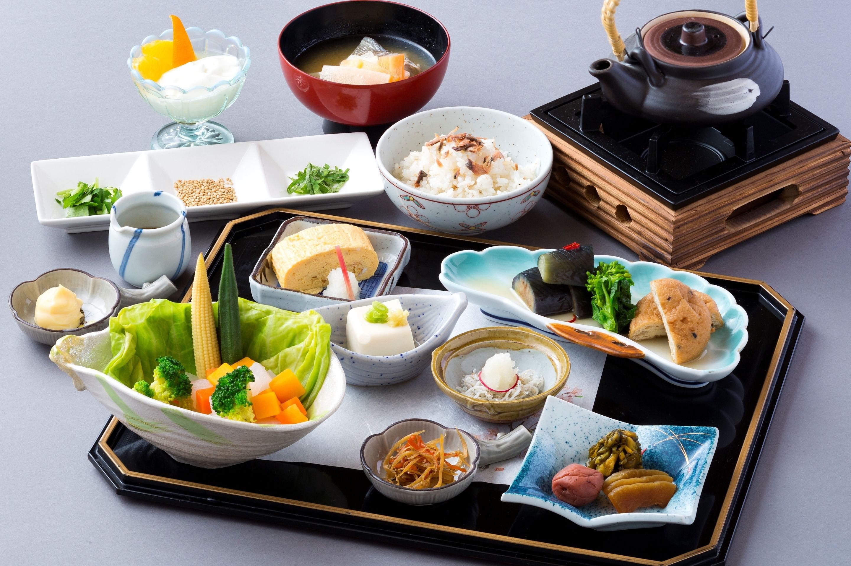 A traditional Japanese meal setup with various dishes and a teapot.