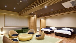 A hotel room with tatami flooring, a traditional Japanese-style room, two beds, and a seating area with woven chairs. - Ryokan Okayama (Myoko)