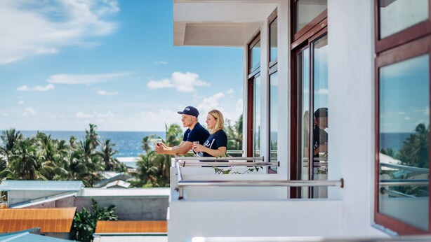 A balcony with a view of the ocean and palm trees. - Rekidhiye Inn (Hithadhoo)