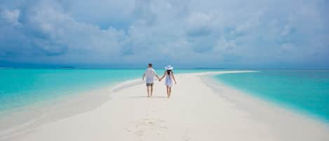 On the beach, white sand, sun loungers, beach umbrellas