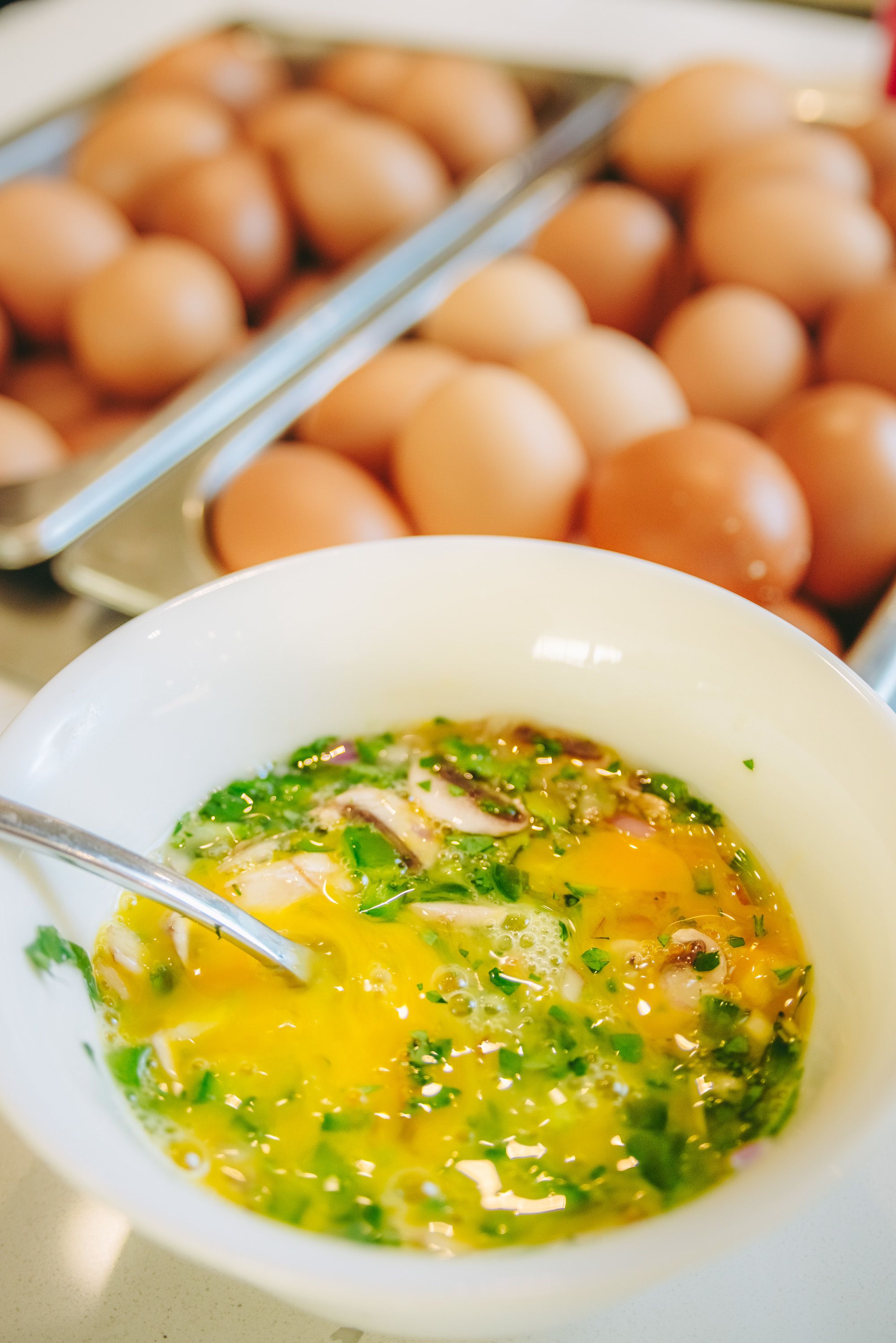 Un bol de sopa amb ous i verdura, amb un plat d'ous al fons.