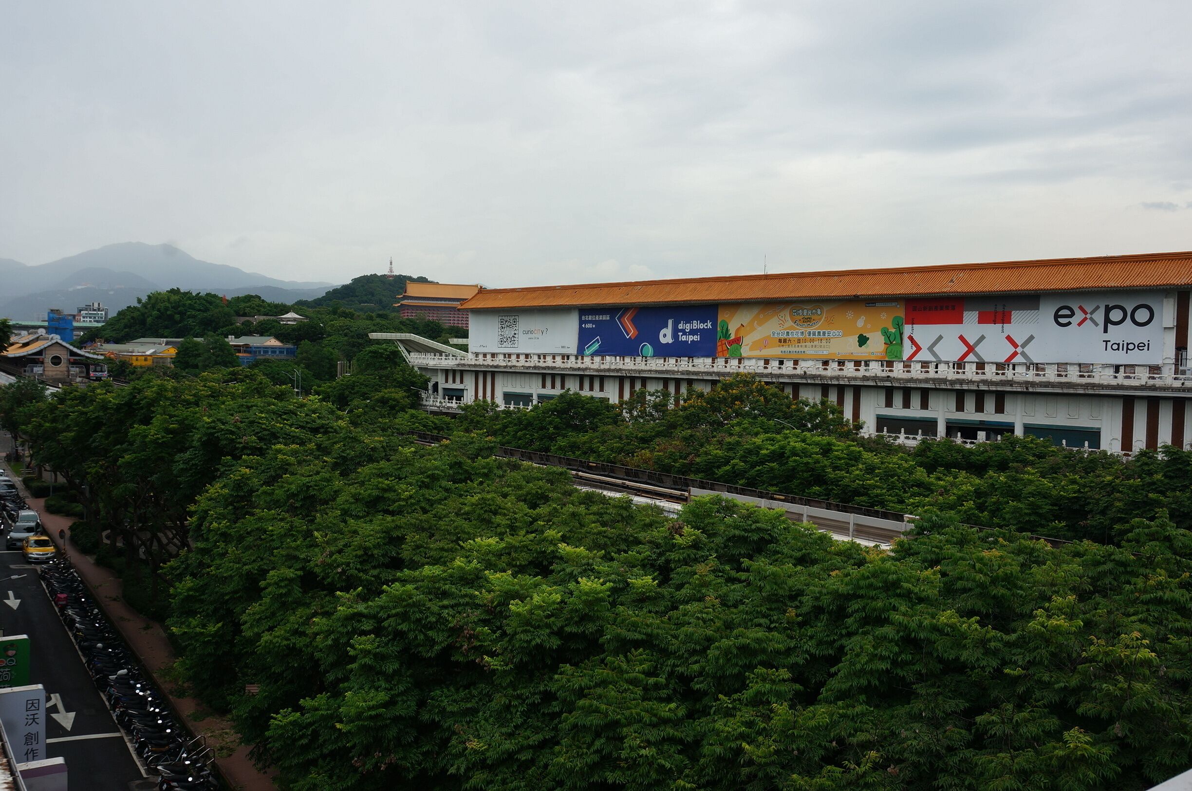 A building with a large billboard advertising an expo in Taipei.