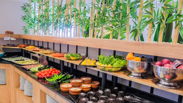 Un bufé con diversos alimentos y recipientes de salsas.