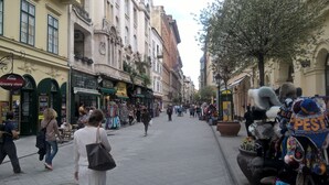 Une rue animée, bordée de boutiques et fréquentée par de nombreux piétons.