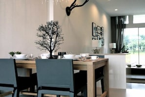 A dining area with a wooden table, blue chairs, and a decorative tree centerpiece.