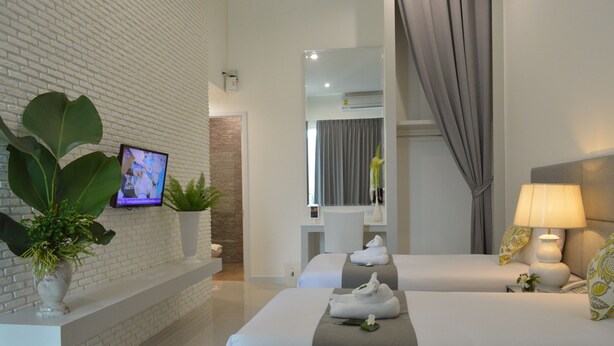 A hotel room with two beds, a TV, a mirror, a lamp, and a potted plant. - Royal Hills Golf Resort and Spa (Nakhon Nayok)