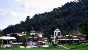 A golf course with a clubhouse, surrounded by lush greenery and hills. - Royal Hills Golf Resort and Spa (Nakhon Nayok)