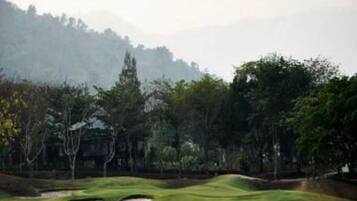 A golf course with sand bunkers and trees.