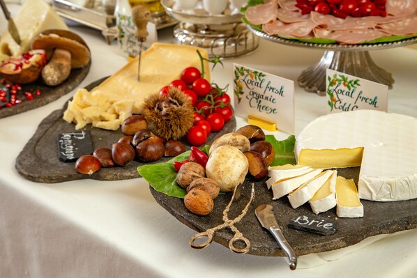 A cheese board with various cheeses, nuts, and fruits.