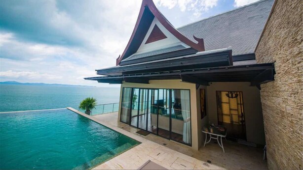 A modern house with a large glass window, a swimming pool, and a view of the sea. - Villa Xilaiwan (Ratsada)