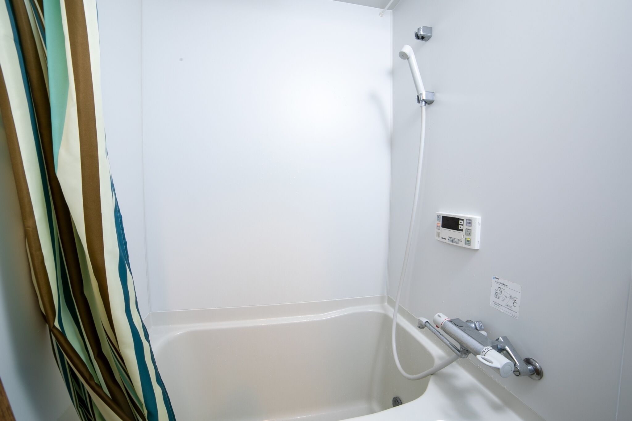 A bathroom with a bathtub, a shower, and a control panel.