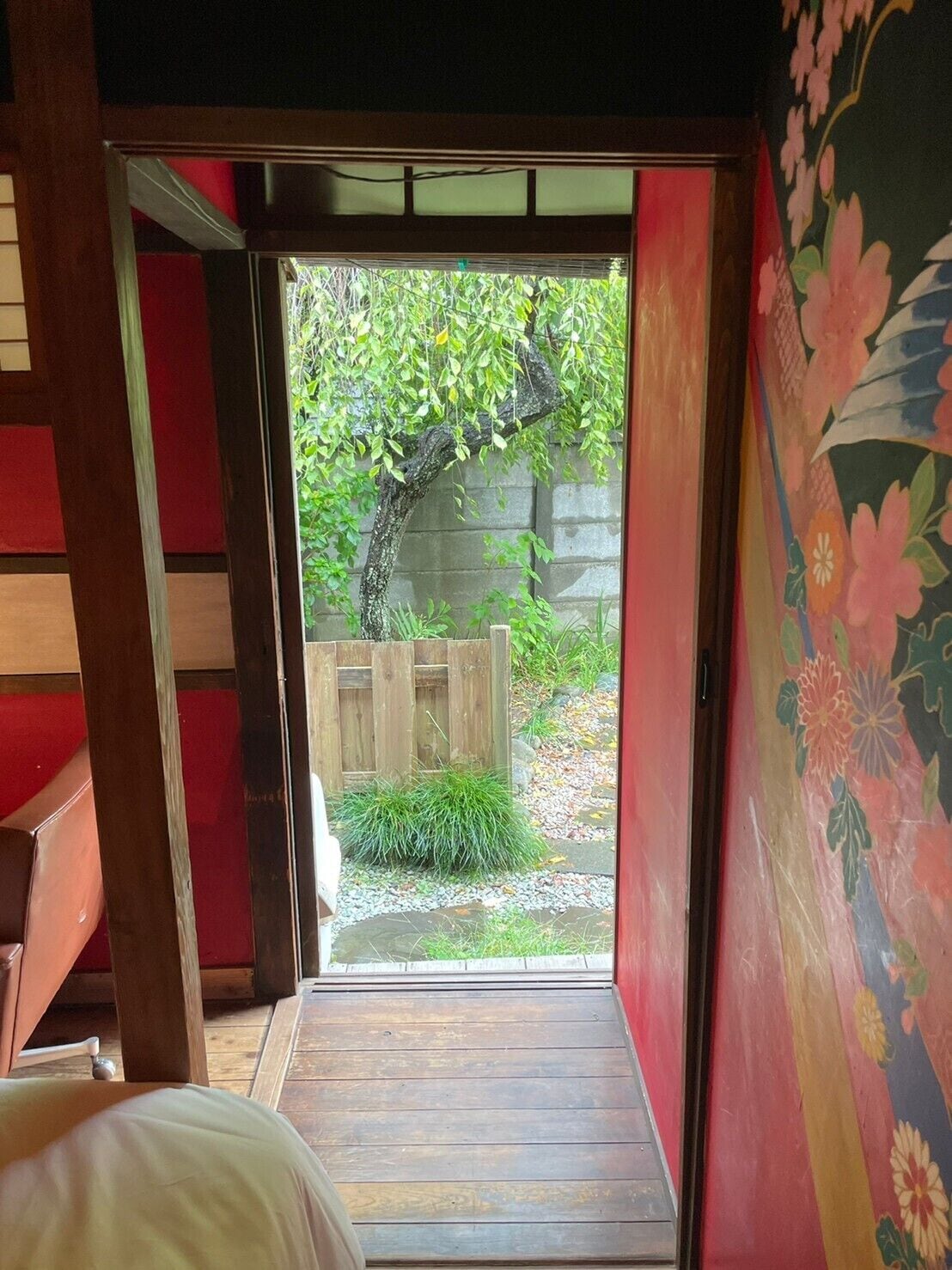A wooden deck leading to a garden with a wooden fence and greenery.