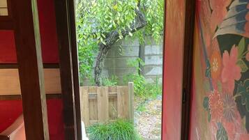 A wooden deck leading to a garden with a wooden fence and greenery.